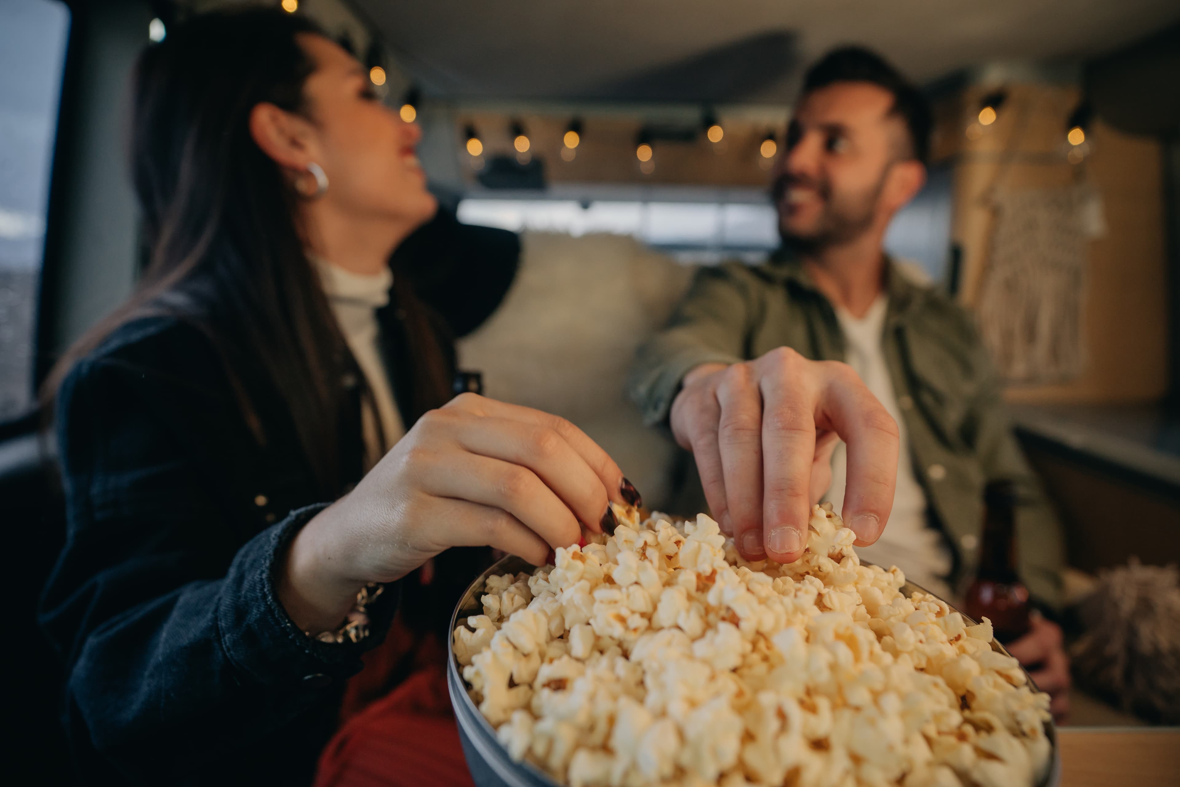 Couple enjoying popcorn together at a drive-in movie night